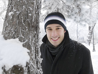 Image showing young man smiling in winter park
