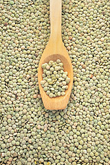 Image showing Wooden spoon and dried green lentils