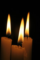 Image showing Three candles burning in the dark