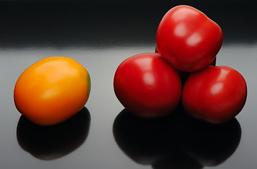 Image showing Multicolored tomatoes on a black backgrouns