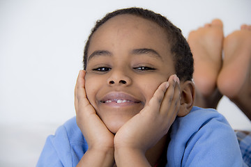 Image showing Young kid with his face resting on his hands