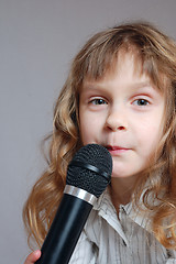 Image showing Cute little girl with black microphone.