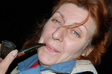 Image showing Portrait of middle-aged woman holding pipe.