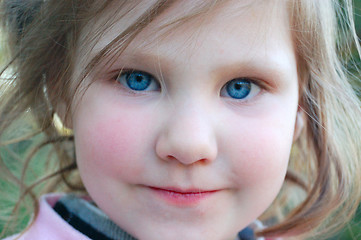 Image showing Little girl with rosy cheeks and blue eyes.