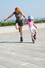 Image showing mother teaching daughter rollerblading