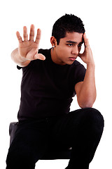 Image showing young latin man, pensive, with his hand in stop signal