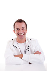 Image showing smiling middle-age man sitting at desk 