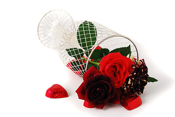 Image showing Three different red tint roses in mesh vase and chocolate candies