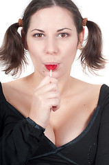 Image showing Portrait of pretty woman in black eating candy