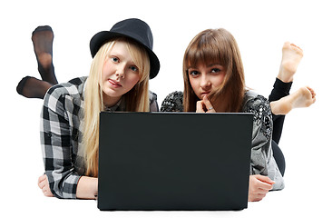 Image showing Two girls lies with computer