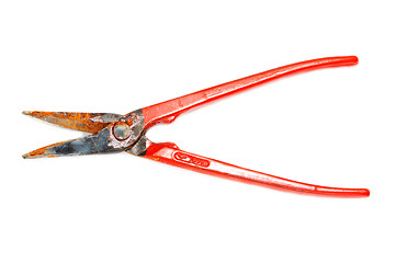 Image showing Rusty scissors on metal with red handle