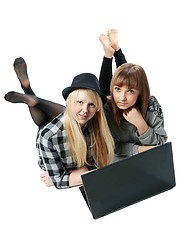 Image showing Two girls lies with computer