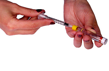 Image showing   Woman hands filling a sirringue with a drug (insulin).