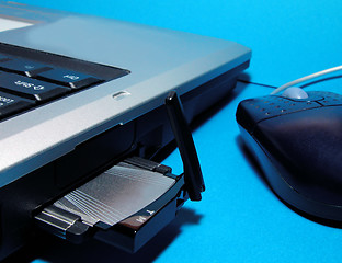 Image showing Computer with wireless internet card and mouse over blue background
