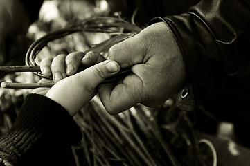 Image showing Man teaching child making a wicker basket