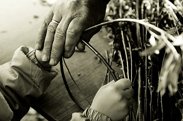 Image showing Man teaching child making a wicker basket