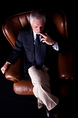 Image showing Pensive mature businessman seated on a chair