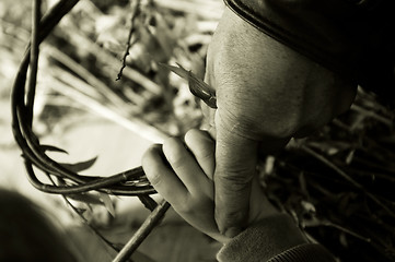 Image showing Man teaching child making a wicker basket