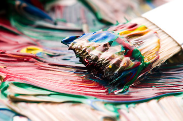 Image showing Brush mixing paint on palette