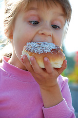 Image showing child biting a doughnut