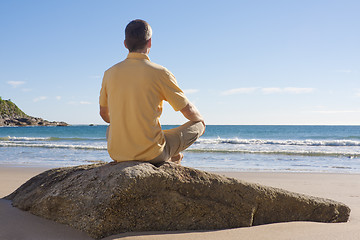 Image showing Man meditating on a beach