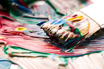 Image showing Brush mixing paint on palette 