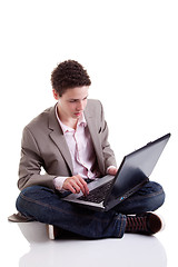 Image showing Young man typing and looking at screen of laptop