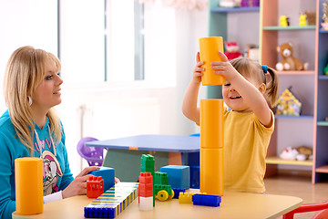 Image showing Teacher and preschooler play with building bricks