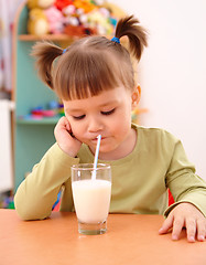 Image showing Gloomy little girl drinks milk