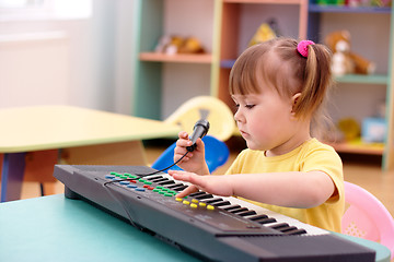 Image showing Girl with electronic piano and microphone