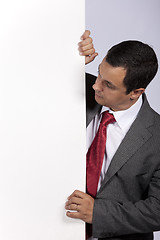 Image showing Businessman holding a blank billboard