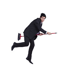 Image showing Businessman flying a broom