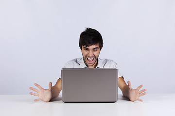 Image showing Young man shouting to a laptop