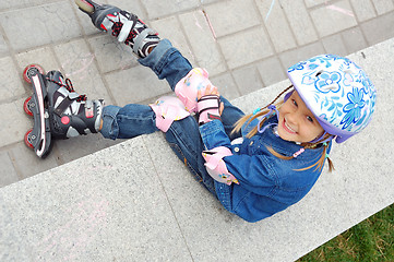 Image showing child with rollerskates and protective helmet and pads