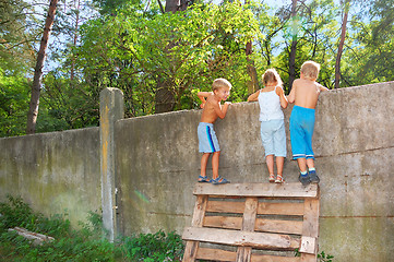 Image showing curious children spying over the fence