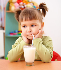 Image showing Gloomy little girl drinks milk
