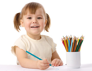 Image showing Cute child draws with color pencils