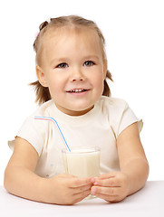 Image showing Little girl drinks milk using drinking straw