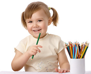 Image showing Cute child draws with color pencils