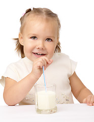 Image showing Little girl drinks milk using drinking straw