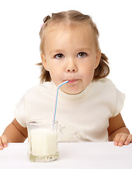 Image showing Little girl drinks milk using drinking straw