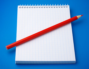 Image showing Blank notepad and a pencil on blue