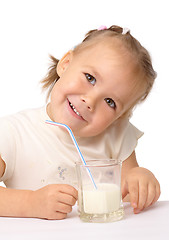 Image showing Little girl drinks milk using drinking straw