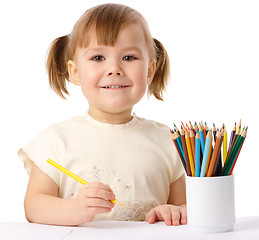 Image showing Cute child draws with color pencils