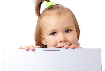 Image showing Cute little girl is looking out from her laptop