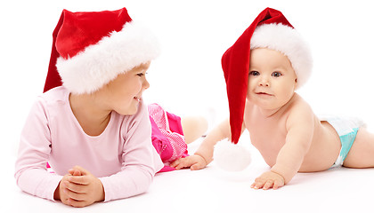 Image showing Two children wearing red Christmas caps and smile