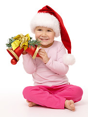 Image showing Little girl holds red Christmas bells