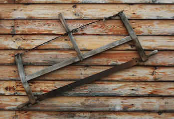 Image showing An old saw hangs on the wall
