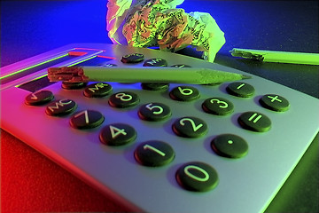 Image showing A business/educational still life with calculator, broken pencil and wad of paper with figures, representing stress and frustration.  Even the sawdust from the snapped pencil remains...