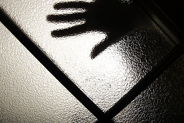 Image showing hand behind the glass   